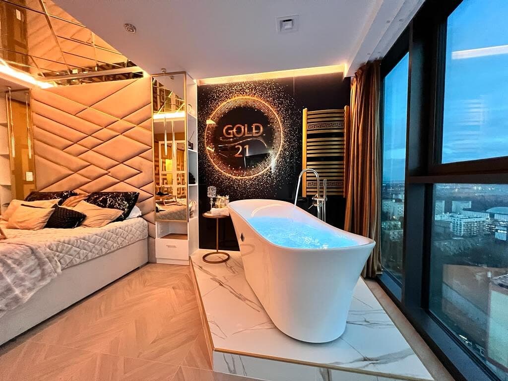 Sypialnia apartamentu GOLD21 z wolnostojącą wanną i widokiem na Szczecin